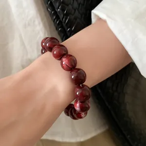 Close-up of marbled dark red beaded bracelet on wrist with elegant vintage style