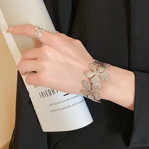 Detailed close-up showing the intricate floral texture of a silver cuff bracelet on a wrist.