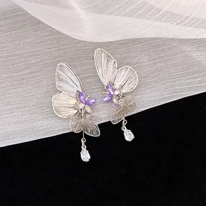 Silver hollow butterfly stud earrings with purple accents and crystal teardrop dangles