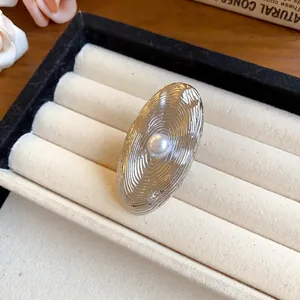 Primo piano di orecchini ovali testurizzati color argento con perla