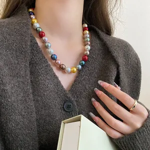 Close-up detail of vibrant multicolored round pearl bead necklace worn by a model