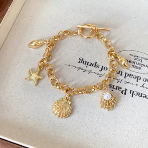 Détail du bracelet à breloques océan avec étoiles de mer, coquillages et perles