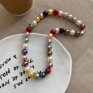 Detailed view of a vibrant dopamine-style necklace featuring multi-colored pearls on a plate