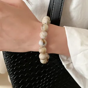 Detail view of a smudge pattern beaded bracelet in retro cream and brown colors.