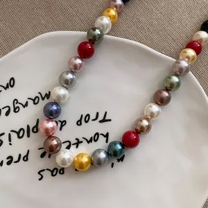 Vibrant dopamine-style colorful round pearl beaded necklace on a decorative plate.