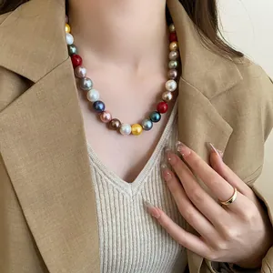 Detailed macro view of a colorful round pearl necklace on a model wearing a chic blazer