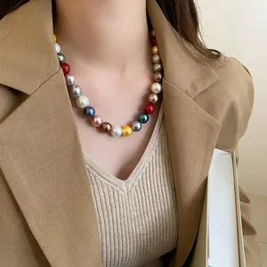 Detailed view of a colorful round pearl necklace worn with a stylish brown blazer