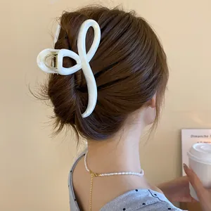 Elegant white marble hair claw clip with a unique looped ribbon design for a chic look.