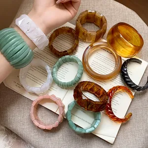 Close-up of marbled resin bangles and chunky acrylic bracelets in various colors