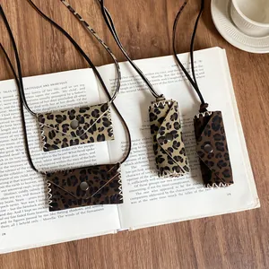 Collection of leopard print leather pendant necklaces arranged on an open vintage book
