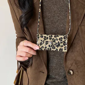 Close-up of a leopard print leather bag pendant necklace on a brown blazer