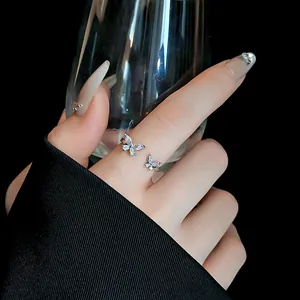 Primo piano di un anello farfalla in argento regolabile con zirconi cubici scintillanti.