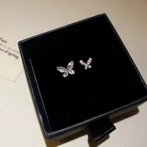 Primo piano di un anello a farfalla in zircone scintillante in una scatola regalo nera.