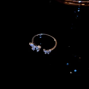 Primo piano dettagliato delle farfalle in zircone su questo anello aperto in argento.