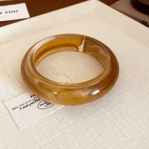 Detailed macro view of a stylish amber resin bangle with a smooth rounded finish and swirl pattern