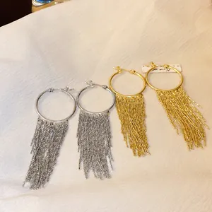 Detail view showing elegant gold and silver plated hoop earrings with long chain tassels.