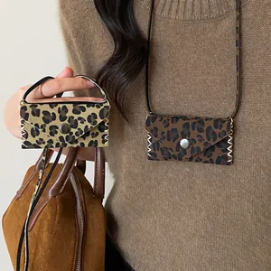 Detail of leopard print leather pouch necklace with snap button and lanyard strap.