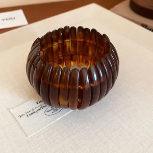Macro detail of a vintage amber marbled resin stretch bracelet featuring a unique ribbed texture