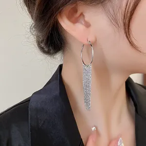 Close-up of elegant silver tassel drop earrings on a model wearing black