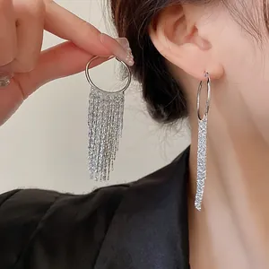 Close-up detail of stylish silver geometric tassel earrings worn by a female model