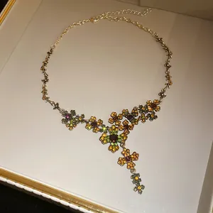 Nahaufnahme einer floralen Vintage-Halskette mit bunten Strasssteinen in einer Geschenkbox