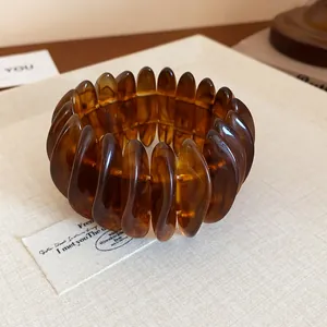Close-up of amber marbled resin bracelet with chunky oval pieces and retro swirled texture