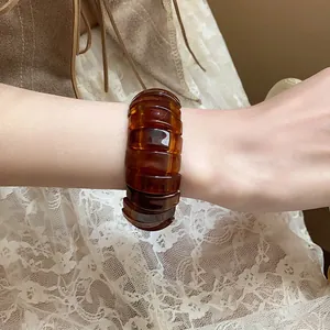 Close-up of amber resin segment bracelet on wrist with lace background