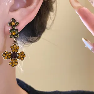 Detailansicht der Vintage-Ohrringe im Hofstil mit Blumenanhängern und orangefarbenem Strass.