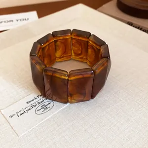 Detailed view of amber tortoiseshell marbled resin chunky link bracelet on fabric