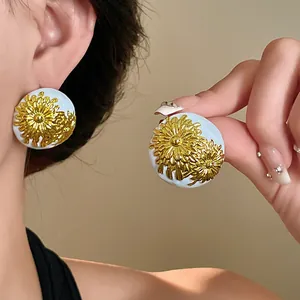 Vista macro detallada de pendientes de botón vintage con diseño de crisantemo dorado