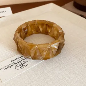 Close-up of a stylish amber marbled resin stretch bracelet with geometric segments