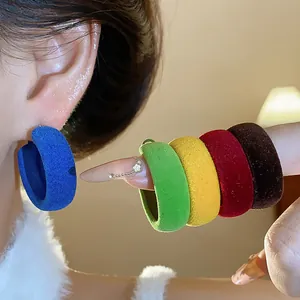 Close-up of colorful velvet flocking hoop earrings in various winter colors