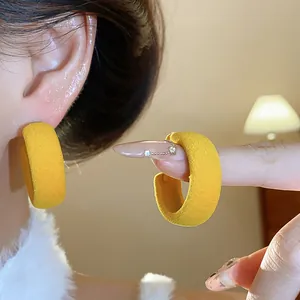 Detailed view of yellow flocking circular hoop earrings with soft velvet texture
