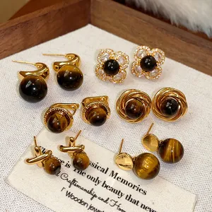 Dettaglio di orecchini vintage in pietra occhio di tigre con placcatura in oro