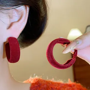 Detailed macro view showing the soft texture of red velvet flocked circular hoop earrings