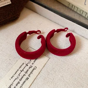 Detailed macro view of wine red flocked hoop earrings with elegant soft velvet texture.