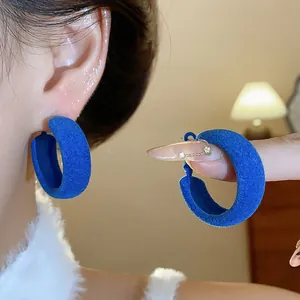 Detailed view of blue flocked thick hoop earrings with an elegant velvet texture