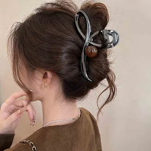 Detailed back view of a minimalist black cross hair claw clip on a bun updo.