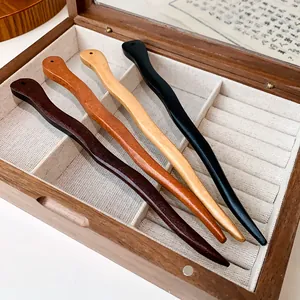 Detailed view of four elegant handcrafted wooden hairpins inside a linen-lined box