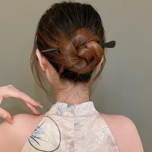 Detail view of a black wooden hair stick used in a traditional Chinese bun