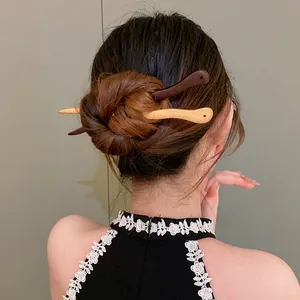 Back view of a bun styled with two elegant peach wood hairpins in traditional Chinese style.