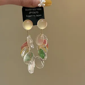 Close-up detail of geometric multi-colored shell tassel earrings with silver needles