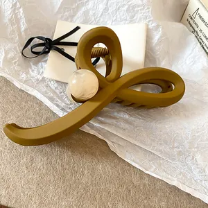 Pince à cheveux croisée jaune moutarde mat avec détail perle de marbre élégant