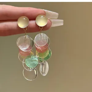 Close-up detail of silver needle geometric shell tassel earrings with colorful discs