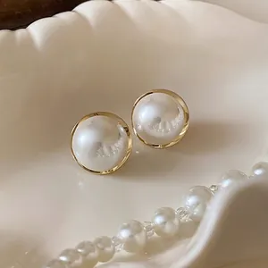 Elegant round pearl stud earrings with gold frame in a classic vintage French style