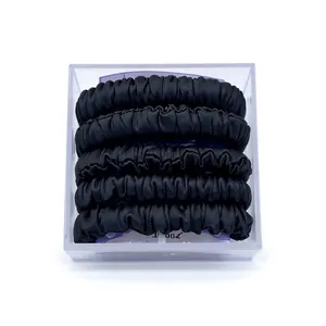 Set of five black fabric ribbed hair scrunchies in a clear square organizer box