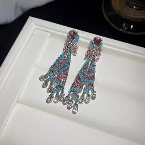 Macro view of ethnic chandelier earrings with pink and turquoise crystal beads