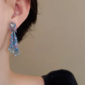 Detailed view of an ethnic style skirt-shaped earring with sparkling colorful diamonds.