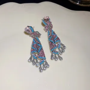 Detailed view of ethnic style dangle earrings with pink crystals and turquoise beads
