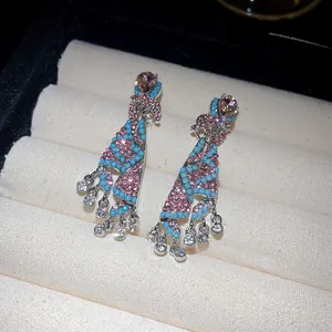Detailed macro view of ethnic skirt-style earrings with pink rhinestones and blue beads